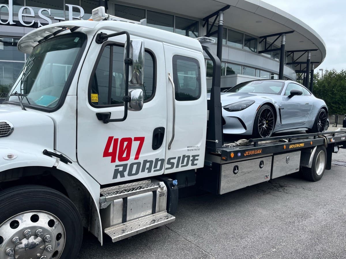 One of our flatbed trucks carrying a single car on a level bed